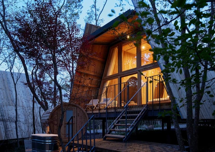 夜の静かな森にたたずむ、温かい光に包まれた小屋
